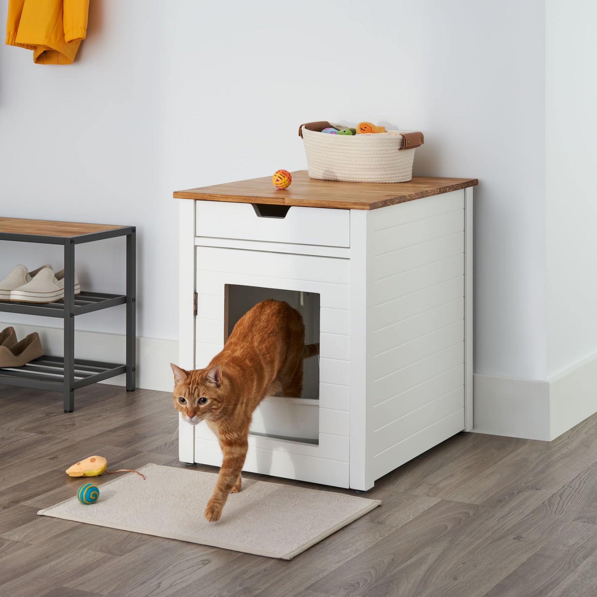 modern litter box end table featuring a chopstick made wood top and a cat walking out of the door frame entrance