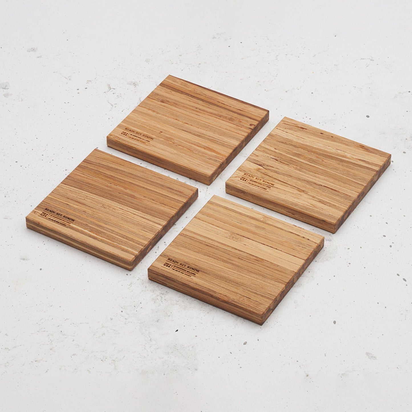 An overhead view of the backside of the entire All day Every day coaster set sitting on a counter