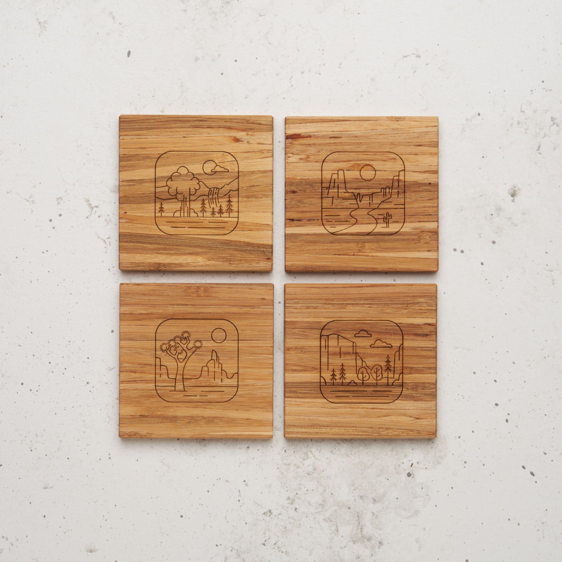 An overhead view of all four of the road trip themed all day every day coasters sitting next to each other on a counter