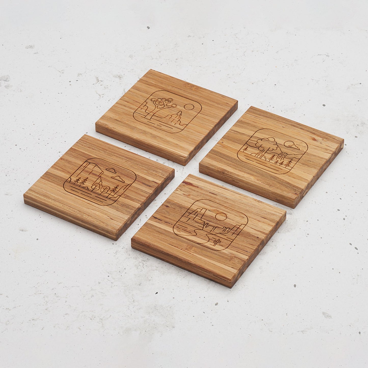 An overhead view of all four of the road trip themed all day every day coasters sitting next to each other on a counter