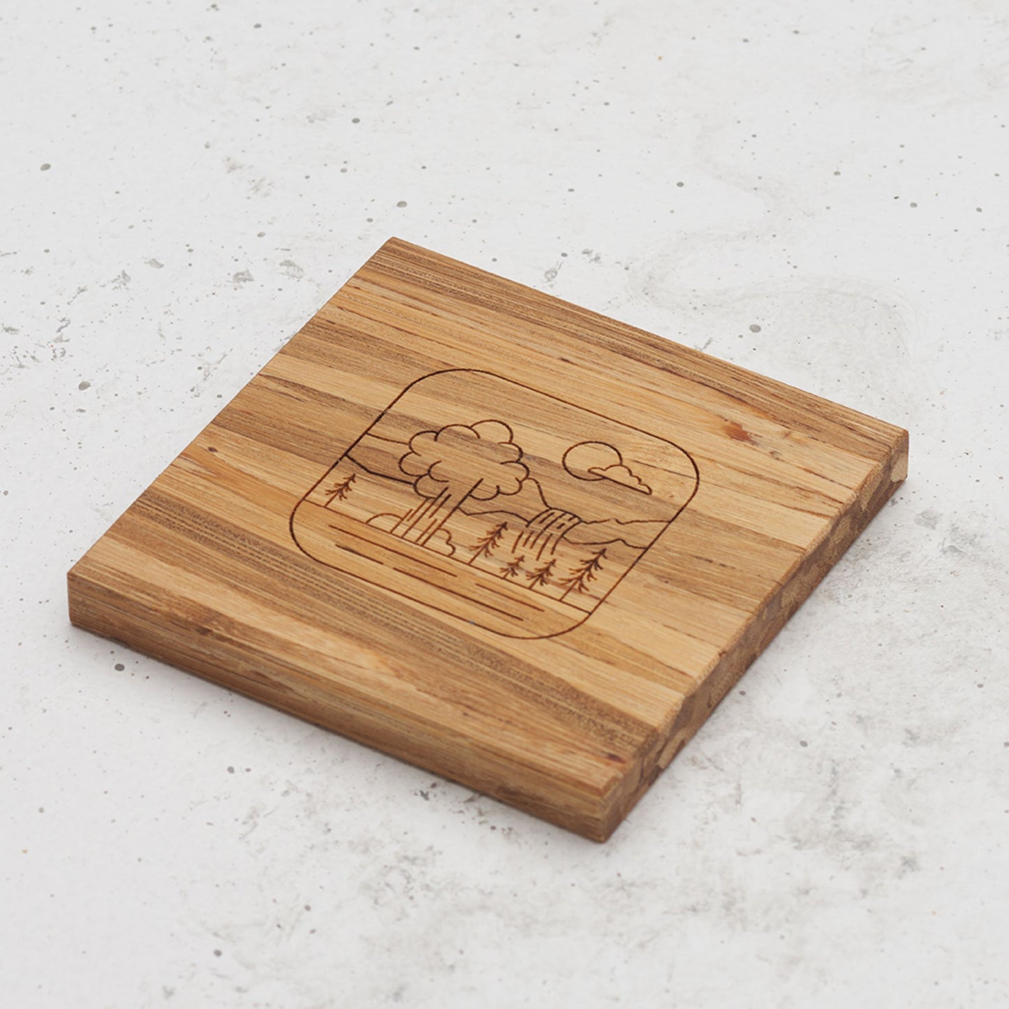 An overhead view of one of the all day every day coasters with an engraved image of a Yellowstone National Park in the middle