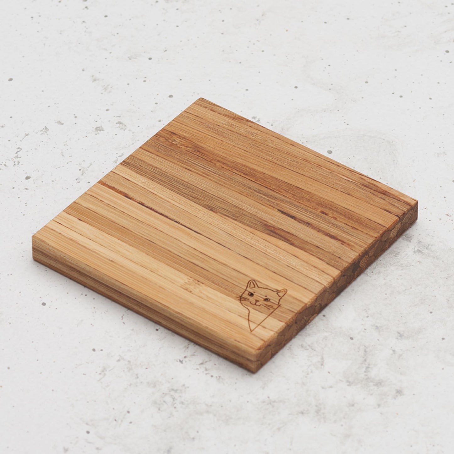 An overhead view of one of the 9 lives cat themed all day every day coasters with a cat's head peeking out from the corner