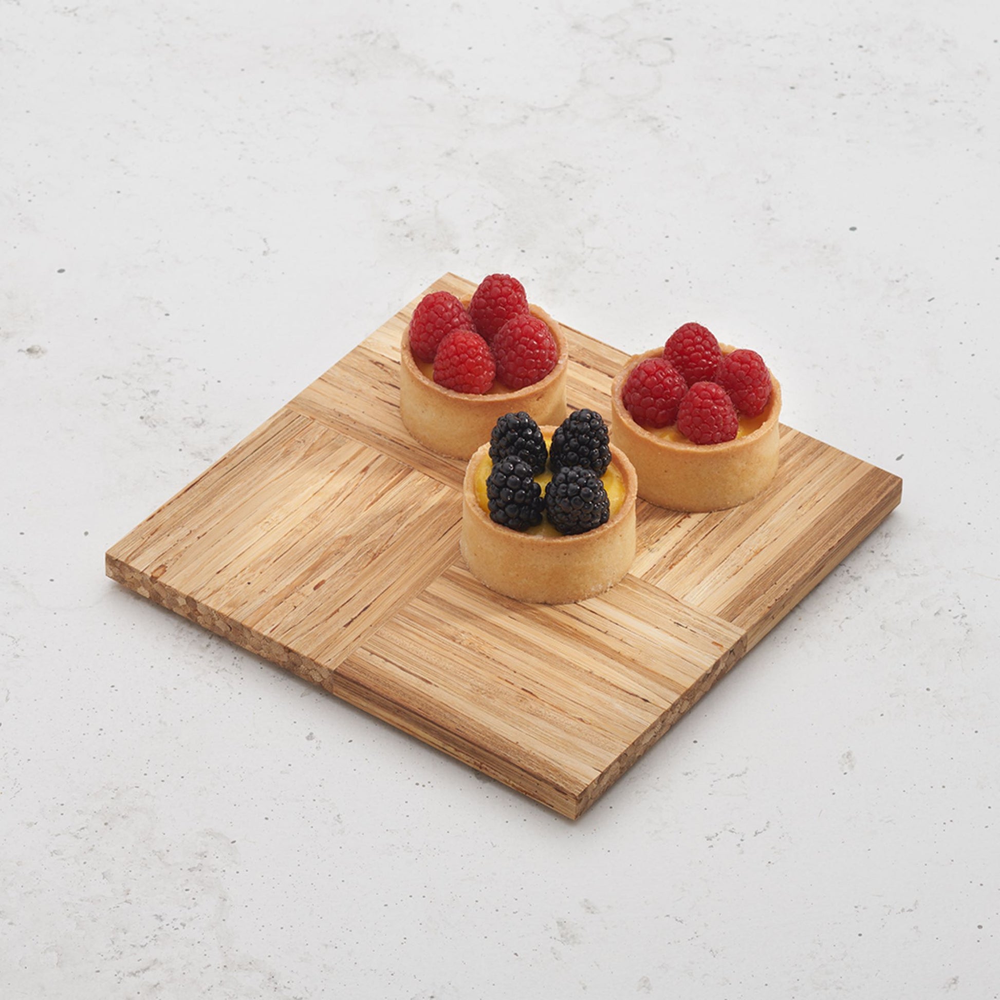 Overhead view of the small smorgas board with three cups of creme brulee and berries on top
