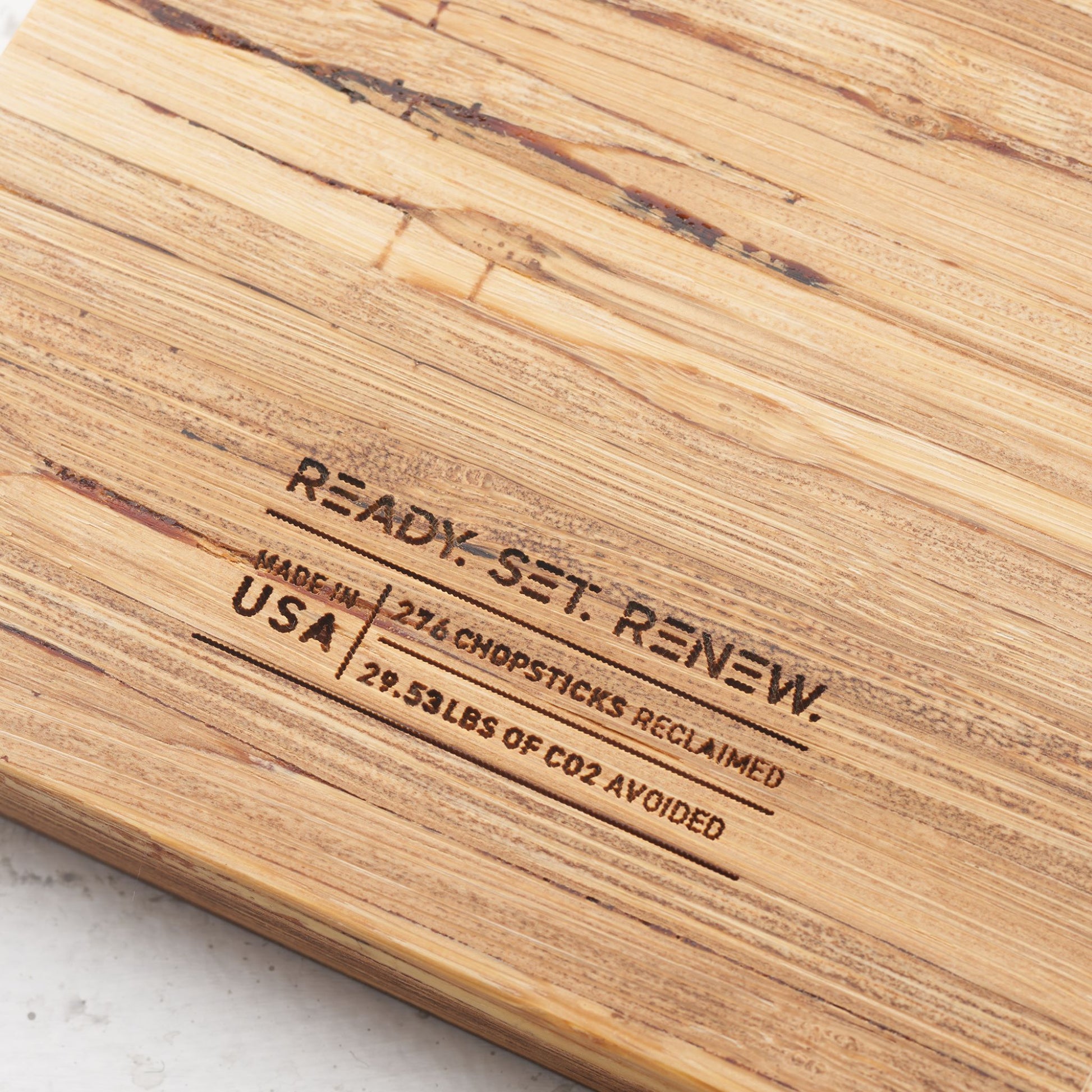 impact metrics on the back of board saying 276 chopsticks reclaimed, 29.53 lbs of co2 avoided