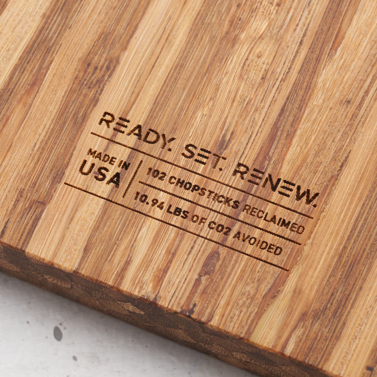 impact metrics on the back of board saying 102 chopsticks reclaimed and 10.94 lbs of co2 avoided