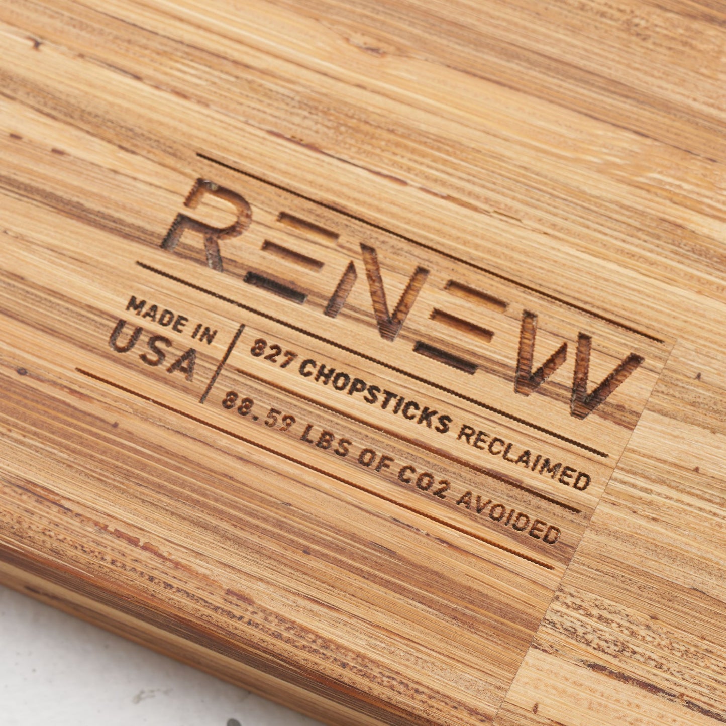 impact metrics on the back of board saying that 827 chopsticks reclaimed, 88.59 lbs of co2 avoided