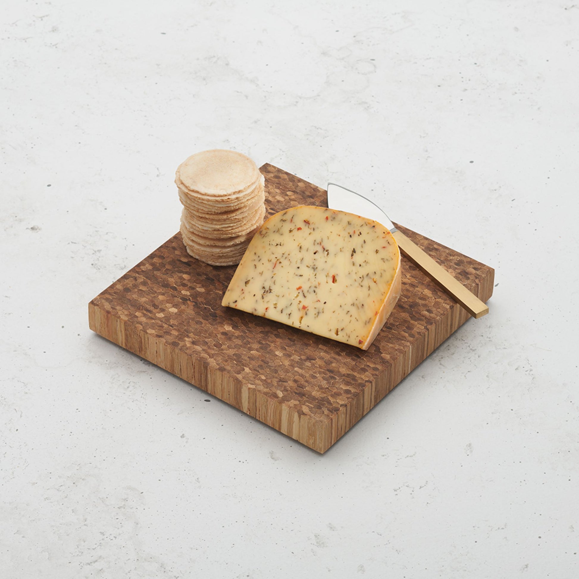 care to share cheese block sitting on a counter top with a cheese wedge placed on top