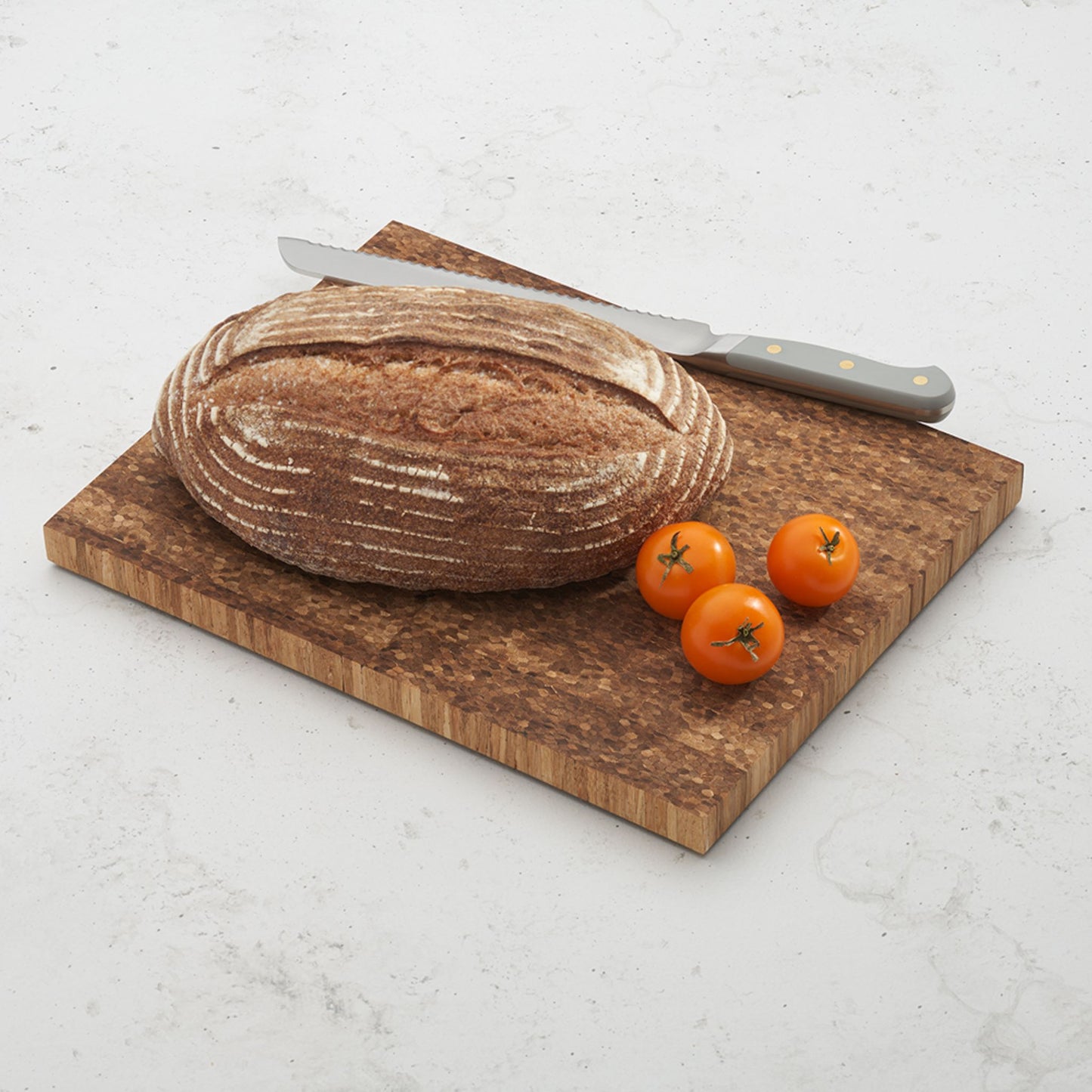 bread board with bread loaf, tomatoes and bread knife