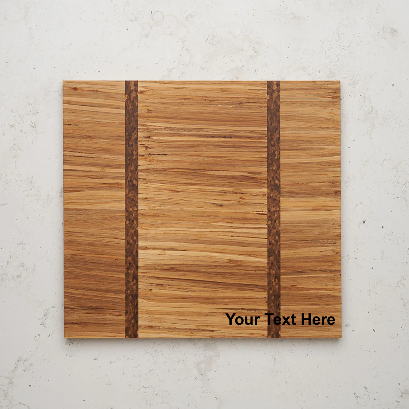 Overhead view of the Large Gather and Graze serving board. A close-up photograph features a square wooden cutting board made of light-colored, horizontally-grained wood, with two vertical inlays of darker, braided-looking wood. The lower right corner has placeholder text that reads "Your Text Here."
