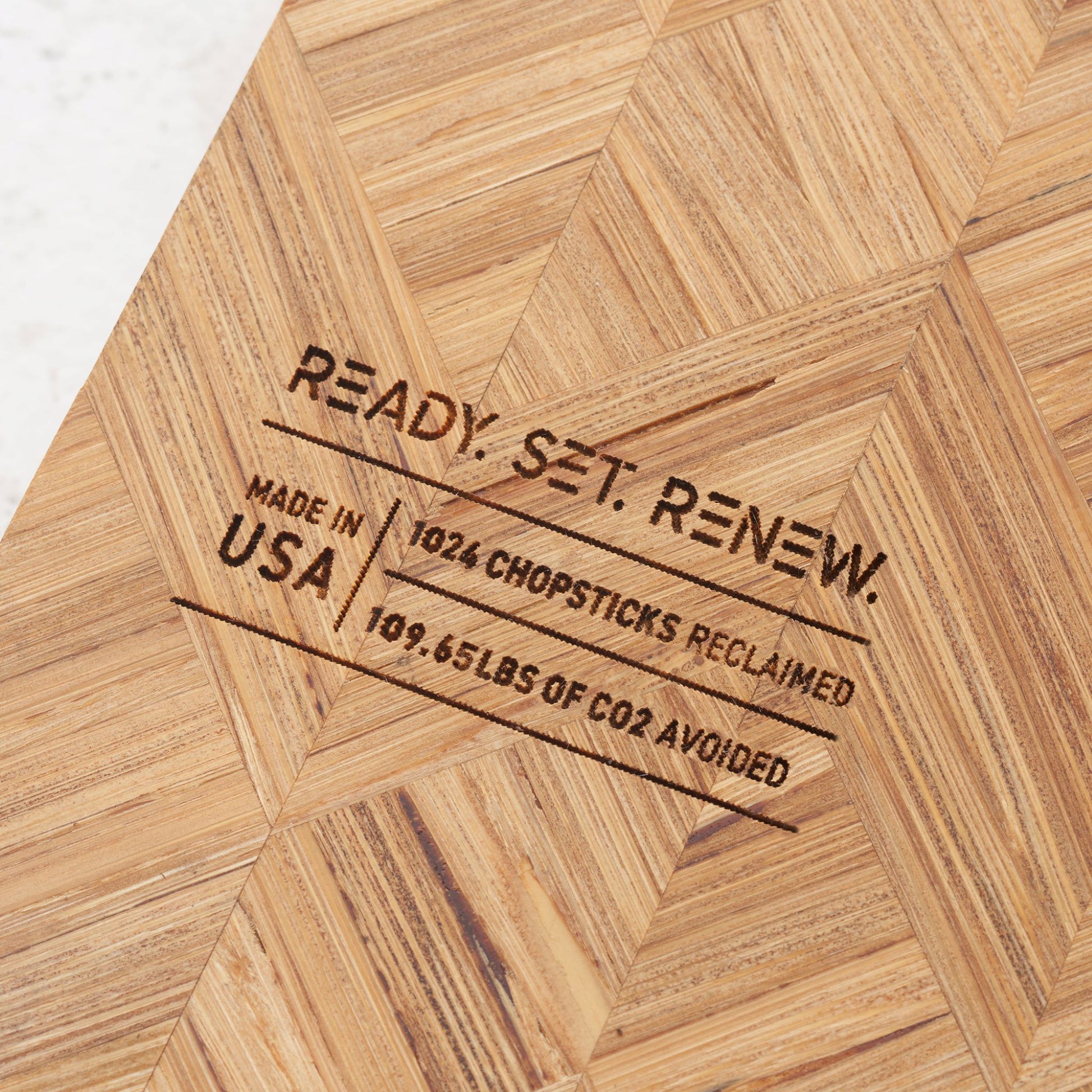 impact metrics on the back of board saying 1024 chopsticks reclaimed, 109.65 lbs of co2 avoided