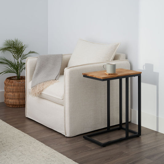 C-shaped side table with a mug on coaster on top in living room