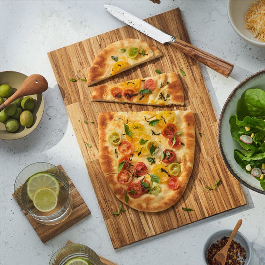 A pizza being cut into three pieces on the large big day serving board