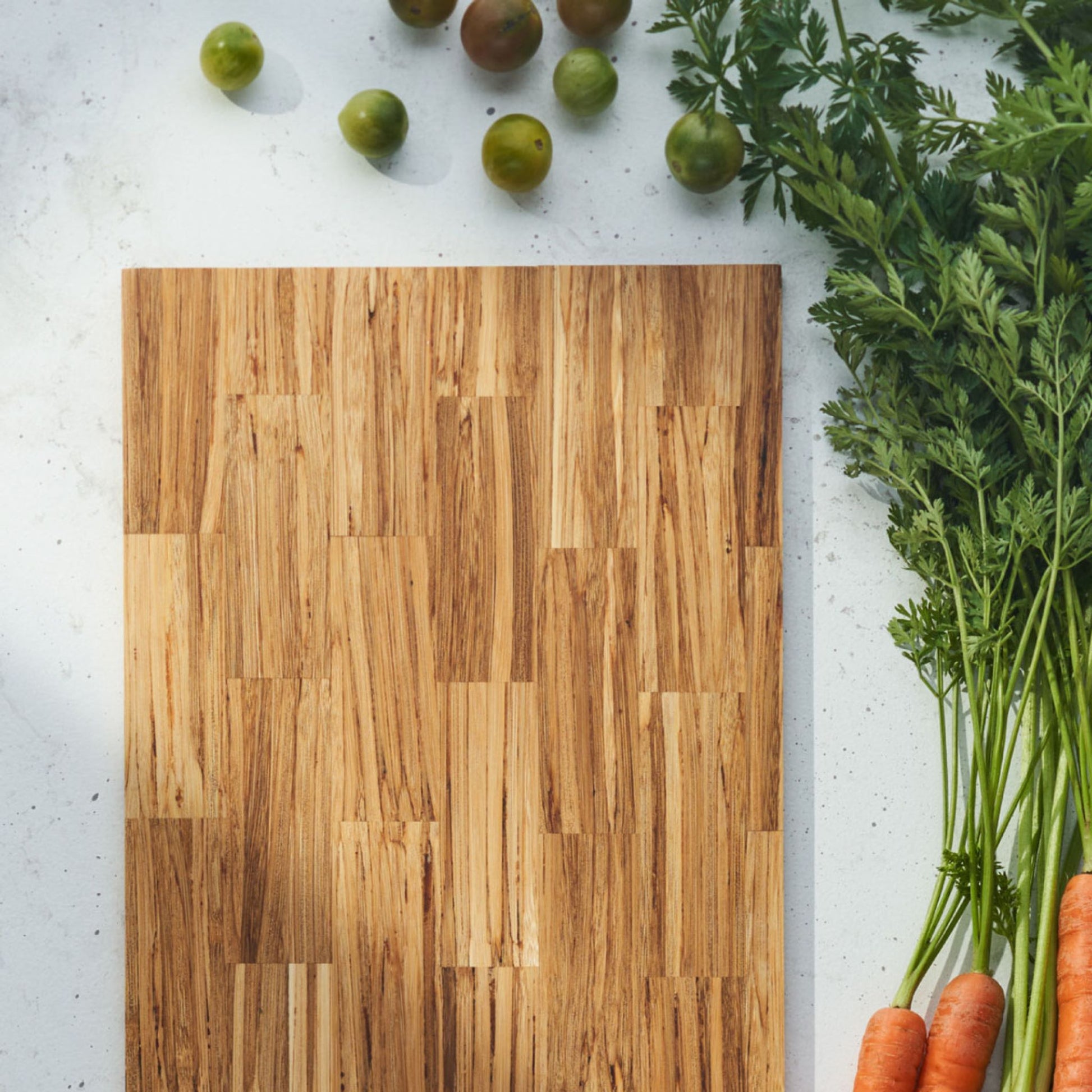 big day serving board with a bunch of carrots and several tomatoes on the side