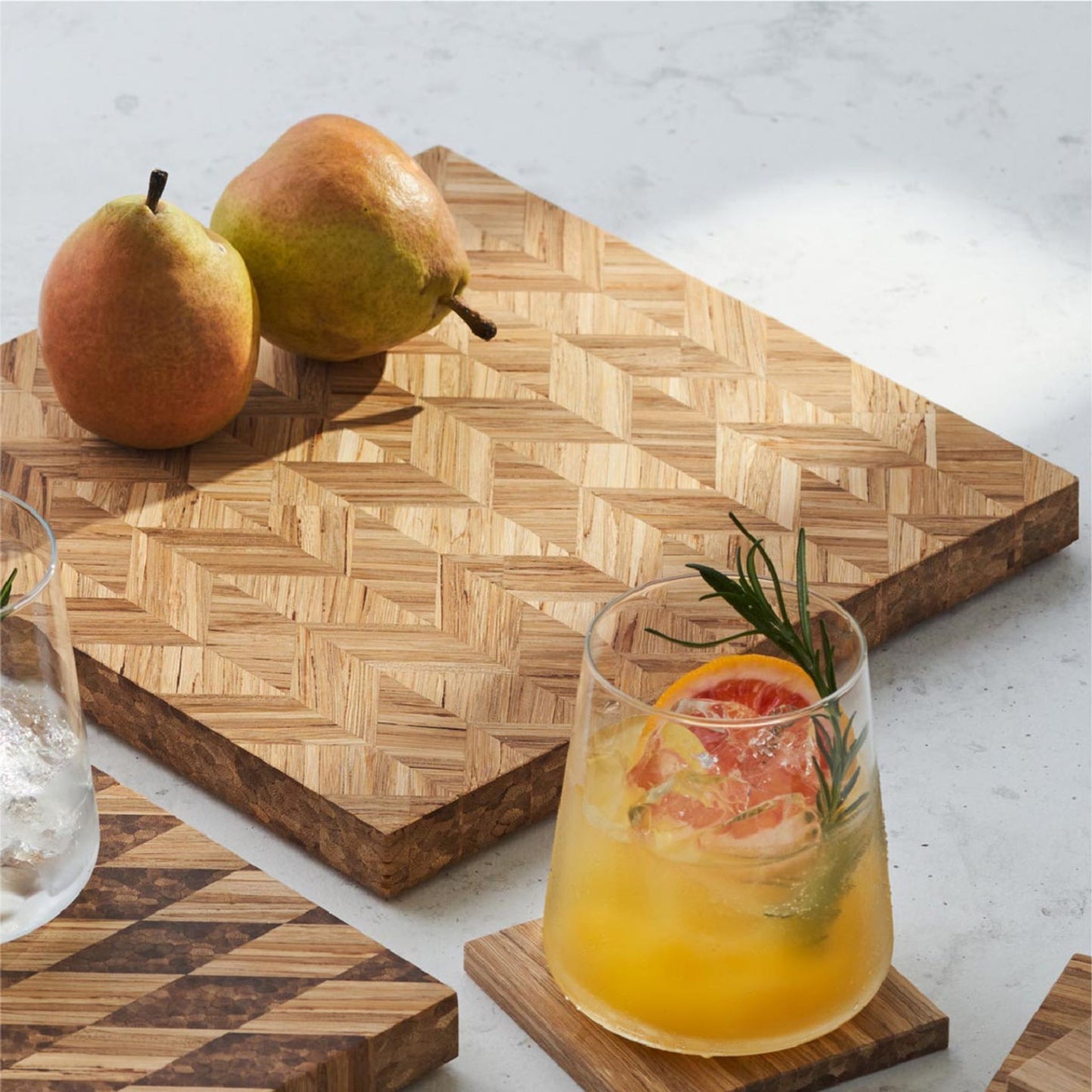Two pears on the wine and dine serving board. A glass of cocktail on the coaster