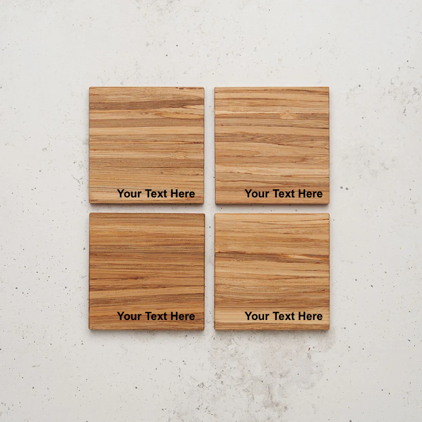 An overhead view of the entire All day Every day coaster set sitting on a counter. Each coaster is made of light brown wood with a prominent grain and has the placeholder text "Your Text Here" engraved in black near the bottom center.