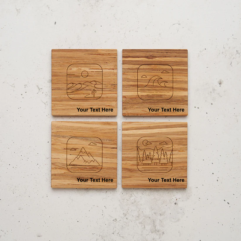 An overhead view of the backside of the entire nature themed all day every day coaster set sitting on a counter. Each coaster features a different laser-engraved nature scene—desert, ocean, mountains, and forest—with the placeholder text "Your Text Here" centered beneath the image.