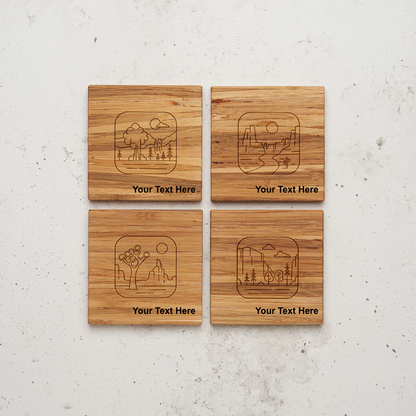 An overhead view of all four of the road trip themed all day every day coasters sitting next to each other on a counter. Each coaster is engraved with a minimalist, line-art illustration of a nature scene (including a waterfall, a desert canyon, a Joshua tree, and a forest) with the placeholder text "Your Text Here" below the artwork.
