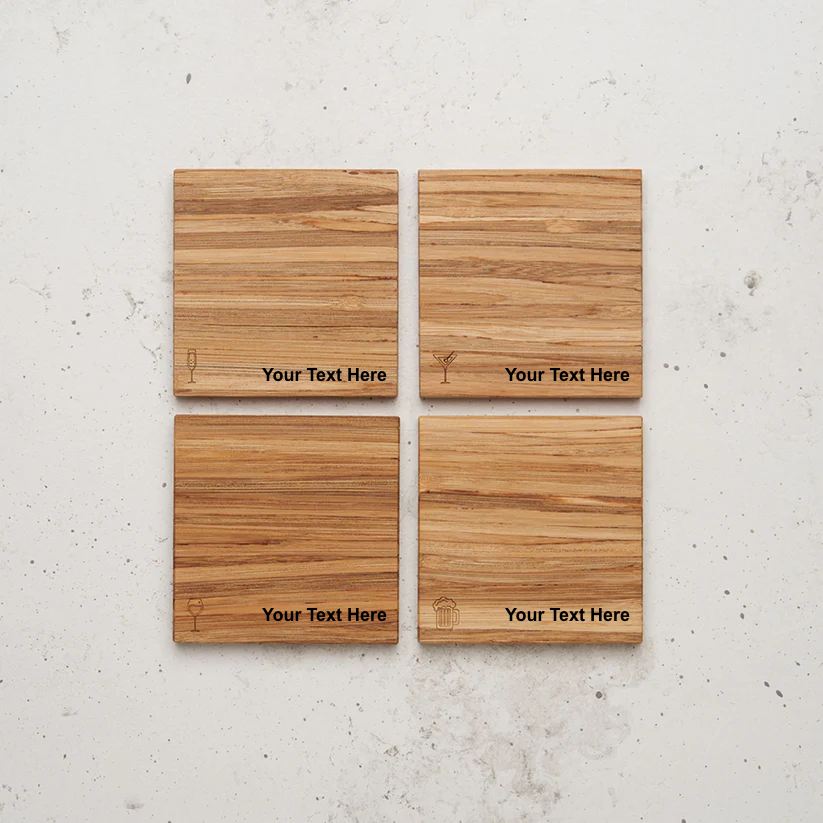 An overhead view of the backside of the entire happy hour themed all day every day coaster set sitting on a counter. Each coaster features an engraved drink icon—a champagne flute, a martini glass, a wine glass, and a beer mug—with the placeholder text "Your Text Here" beneath it.