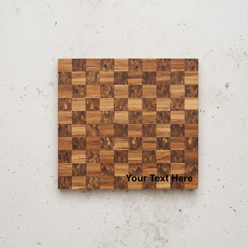 Overhead view of the checkered pattern on the game night snack board. The board alternates between squares of light-brown grain and squares made of small, tightly packed, darker-brown wood pieces, with the placeholder text "Your Text Here" centered near the bottom.